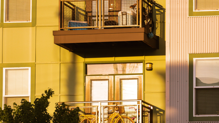 Apartment building with bike on balcony.