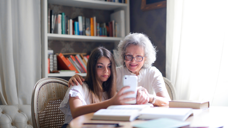 Older adult woman with granddaughter and cell phone