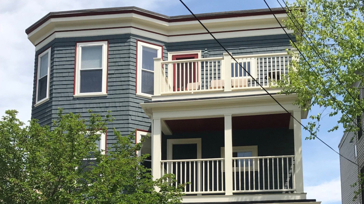 View of blue triple decker house facade.