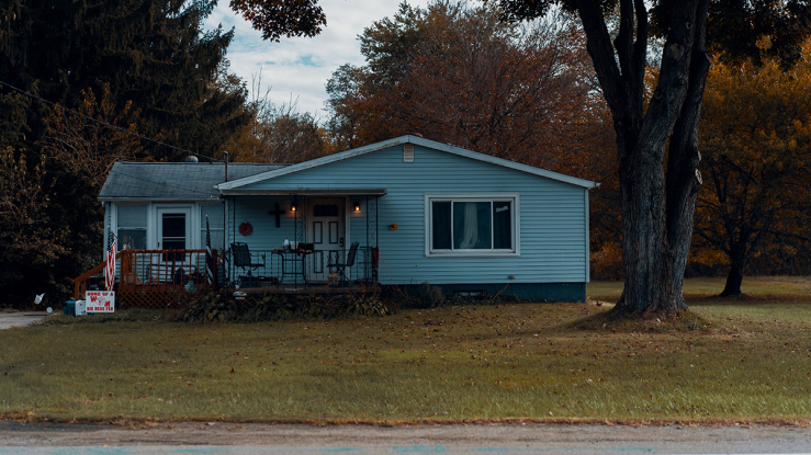 Small ranch house by roadside.
