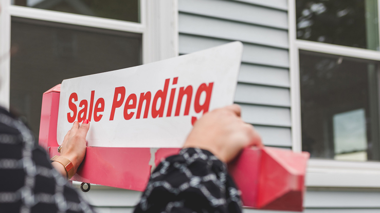 Sale pending sign in front of home.