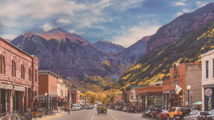 View of small town's main street, with mountains in background.