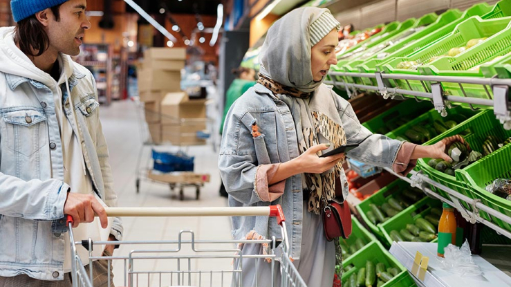 Couple shopping for food and checking costs