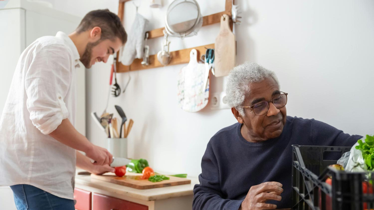 Caregiver cooks food for Black older adult resident
