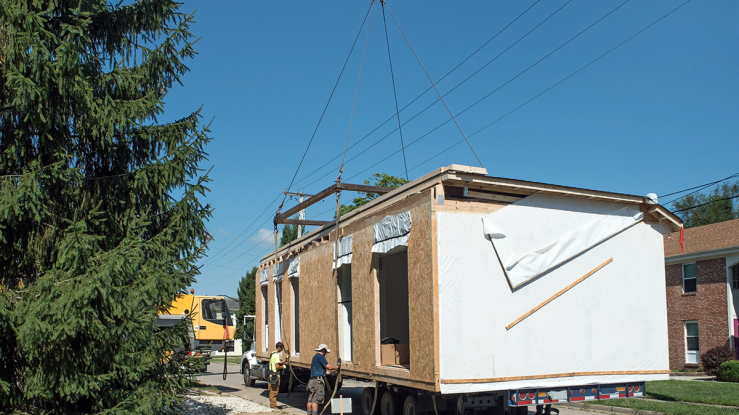 Crane lowering modular building section into place.