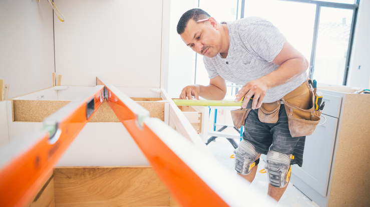 Contractor measuring kitchen counters for a remodeling project