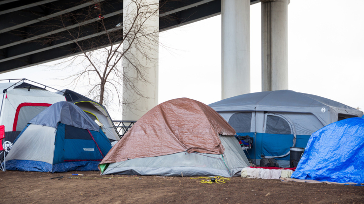 Tent encampment under an overpass.