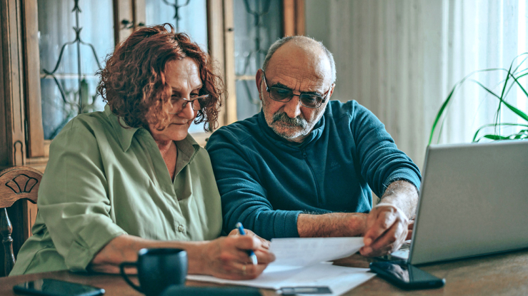 Older adult couple paying bills.