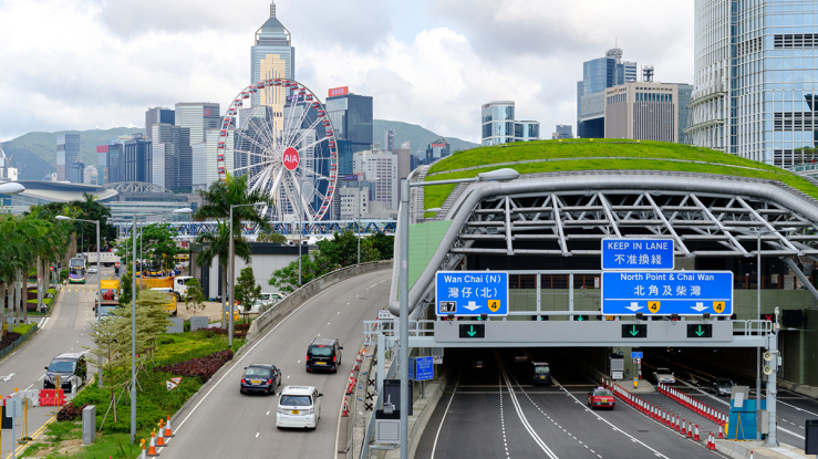 Highway and tunnel against Hong Kong skyline.