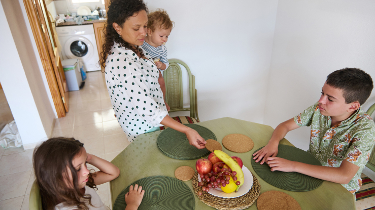 Mother and three kids at kitchen table.