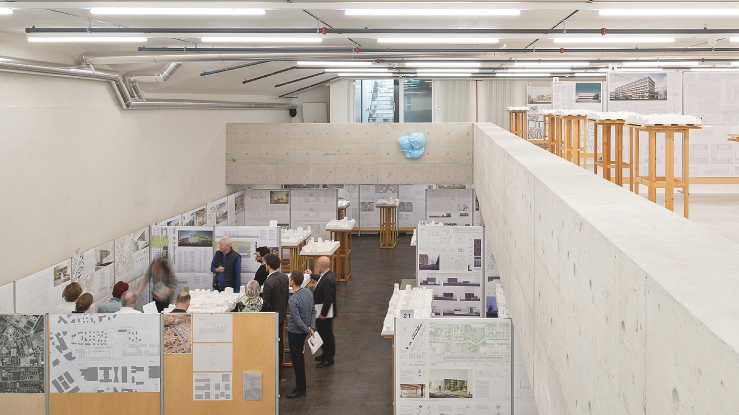 Group reviewing competition proposals in a modern space.