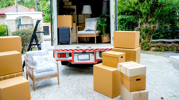 Moving truck and boxes in a driveway.