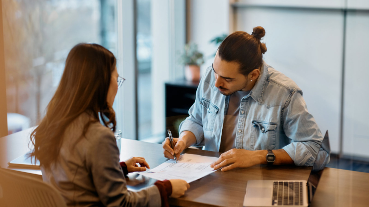 Man signing lease paperwork in realtor's office.