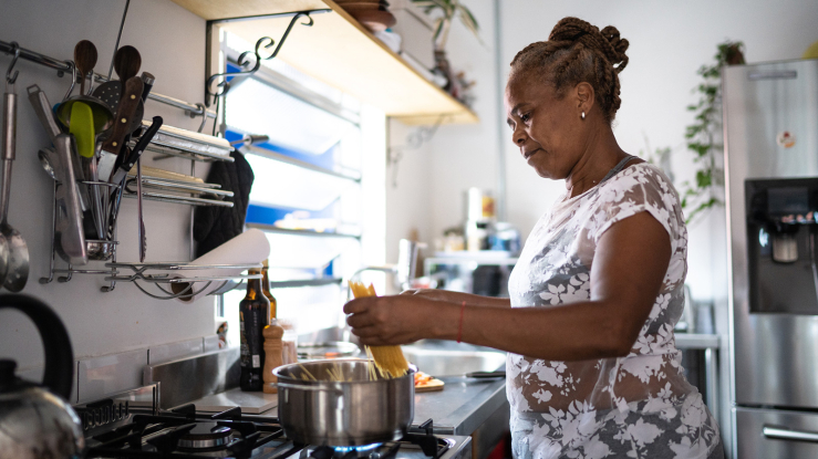 Older adult woman cooking dinner at home.