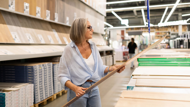 Woman browsing flooring at a home improvement store.