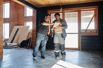 Two people examine plans for a remodeling project