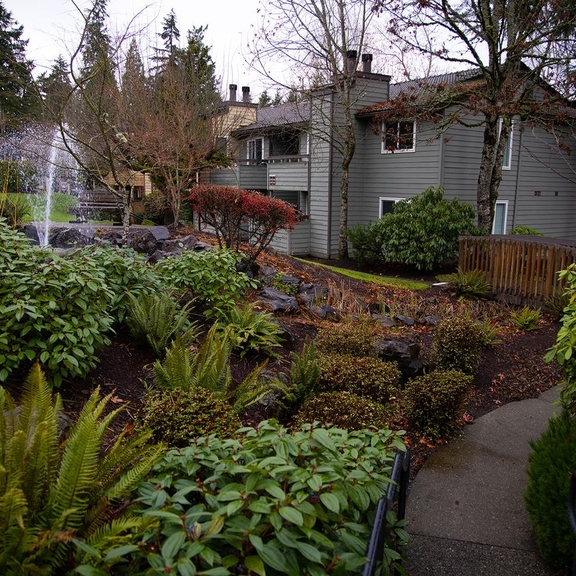 Multifamily housing in leafy, landscaped area.
