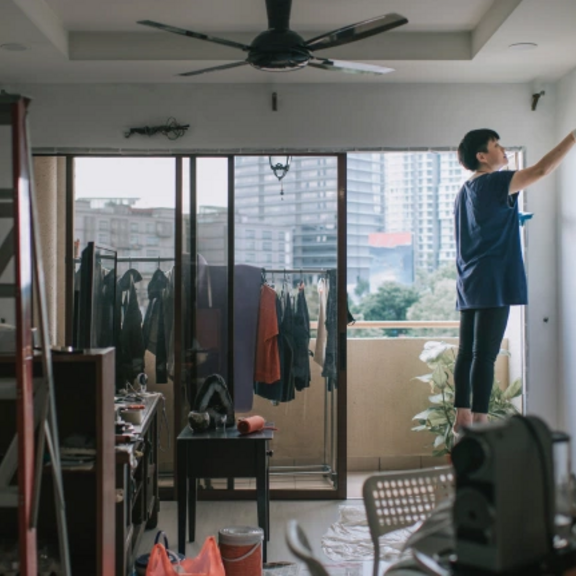 Woman painting a wall in her apartment.