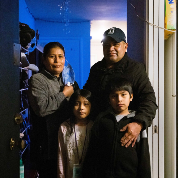 Family standing in their apartment.