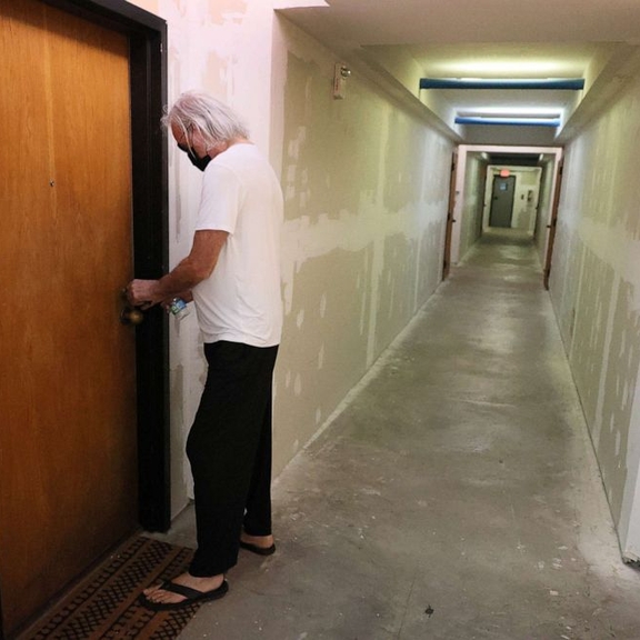 Man entering his apartment within larger building.