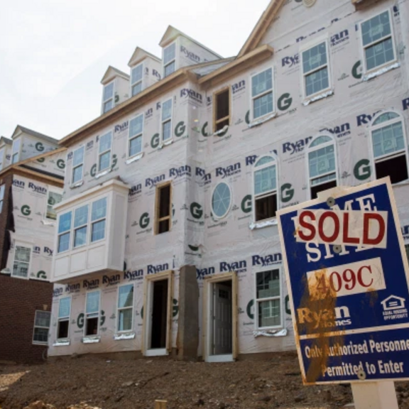 "Sold" sign in front of houses still under construction.