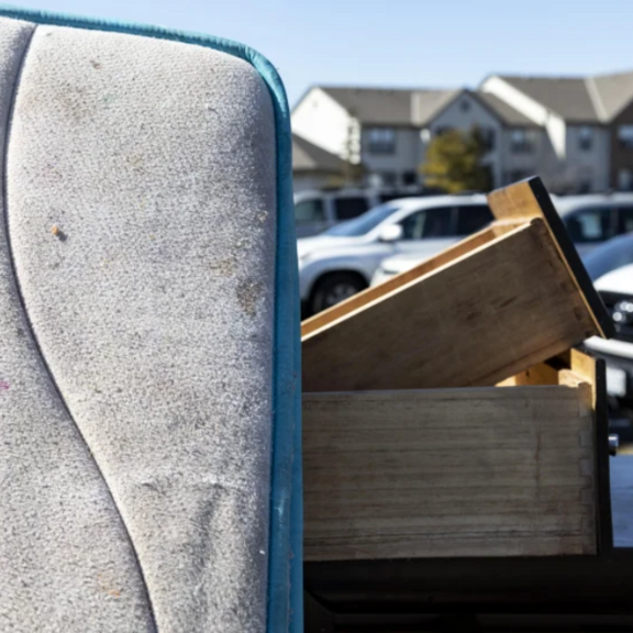 Stack of belongings in residential parking lot.