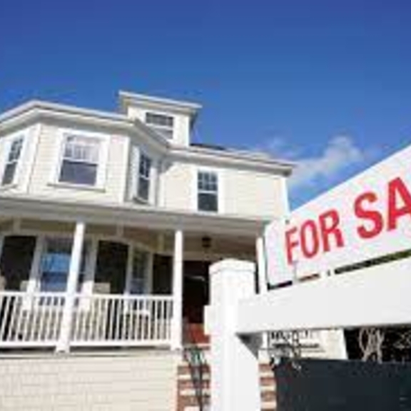 House with for-sale sign in front.