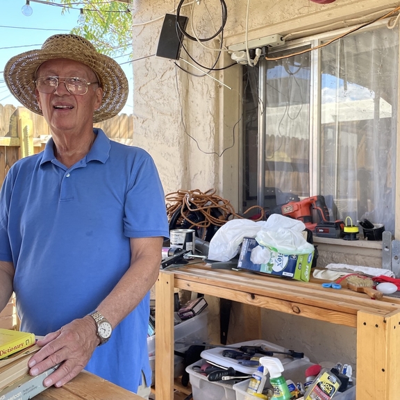 Older man standing in front of home.