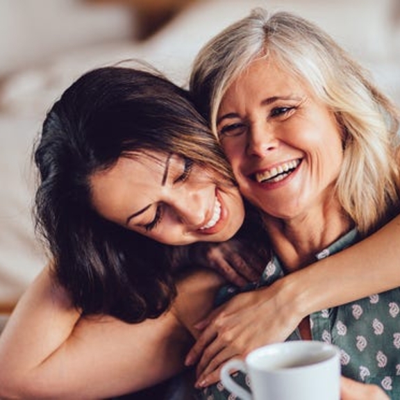 Younger woman hugging older woman.