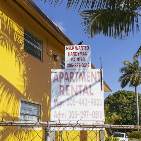 View of "apartment rental" sign in front of multifamily building.