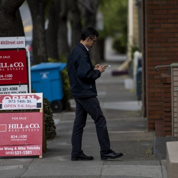 Real estate agent checking phone on the street.