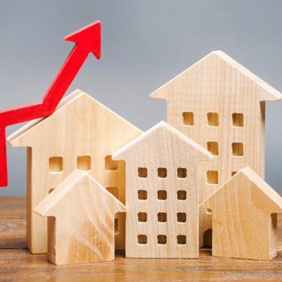 Graphic of wooden houses with rising line indicating price rise.
