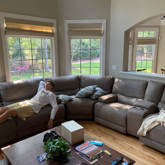 Man lounging on couch inside spacious home.