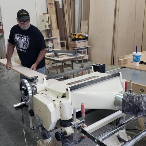 Carpenter cutting board of wood in saw.