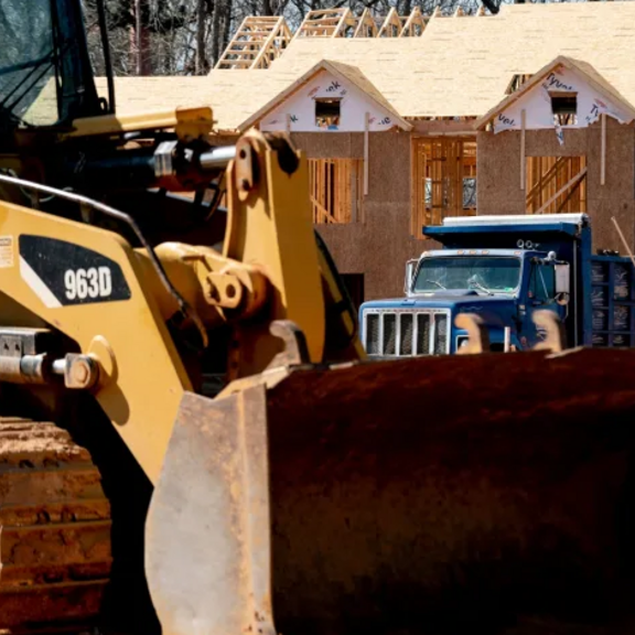 Bulldozer in front of housing construction.