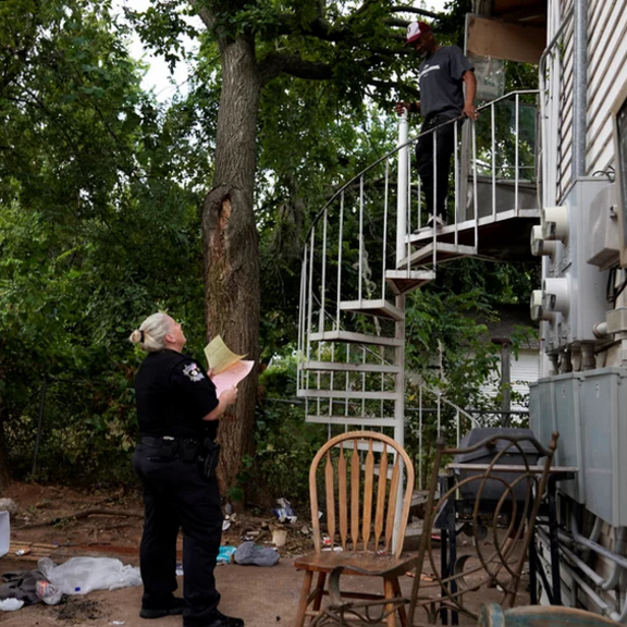 Officer serving eviction order to renter.
