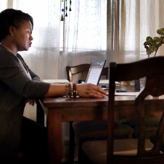 Woman working on laptop in her living room.