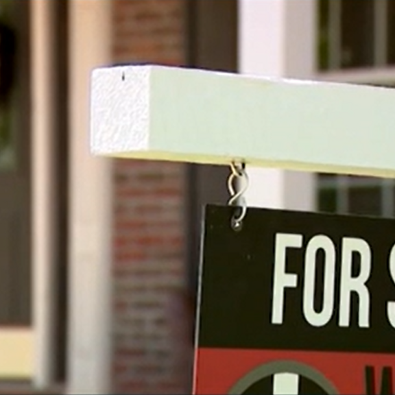 View of for-sale sign in front of home.