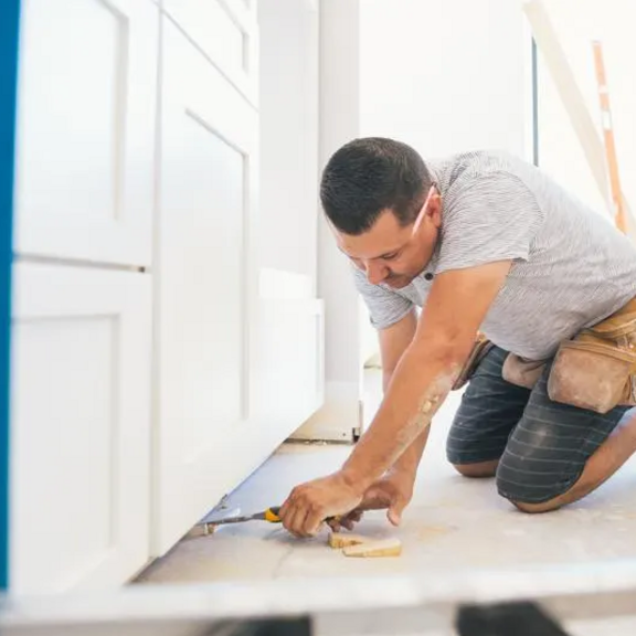 Person measuring under kithcen cabinet.