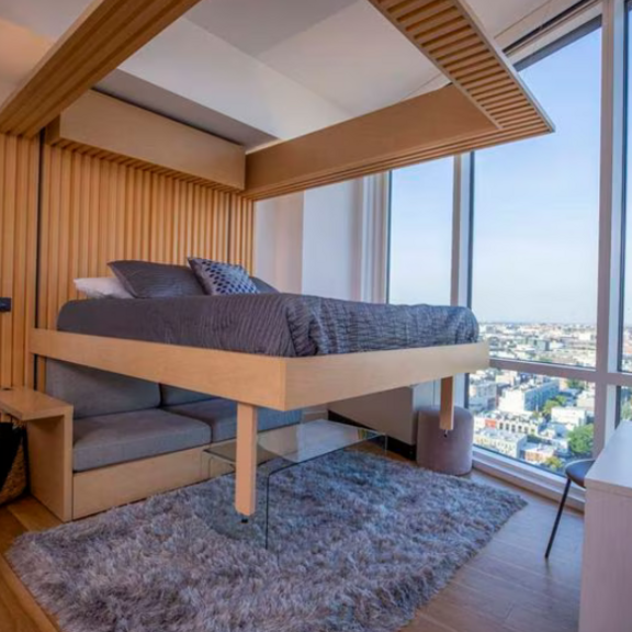 The Ori Cloud Bed, seen here at The Greenpoint apartments in New York City, rises into the ceiling to reveal the sofa below.