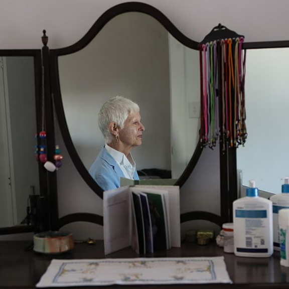 View of older woman sitting by mirror.