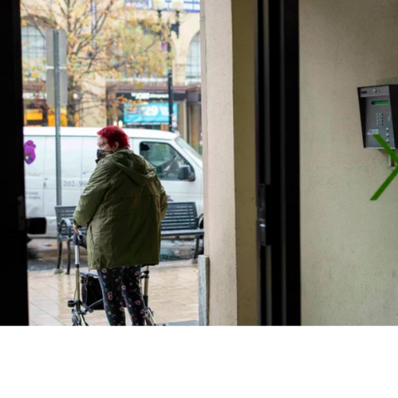 Older women with walker at entrance of her apartment building.