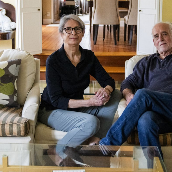 Older couple sitting in large living room.