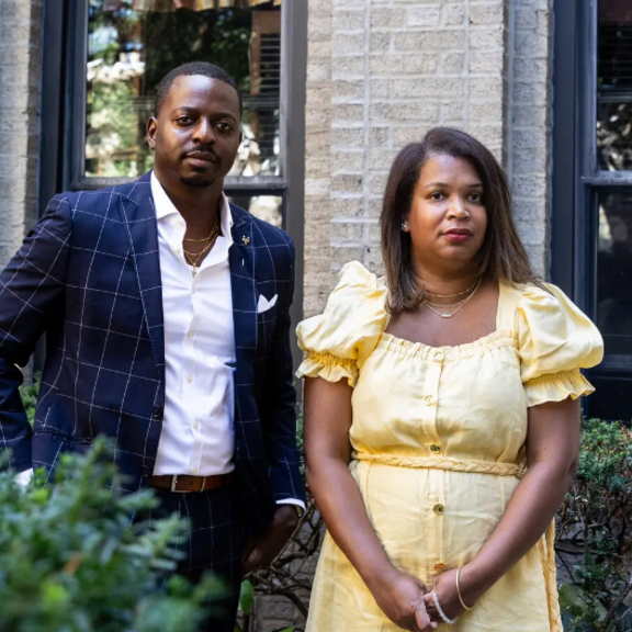 Couple standing in front of their home