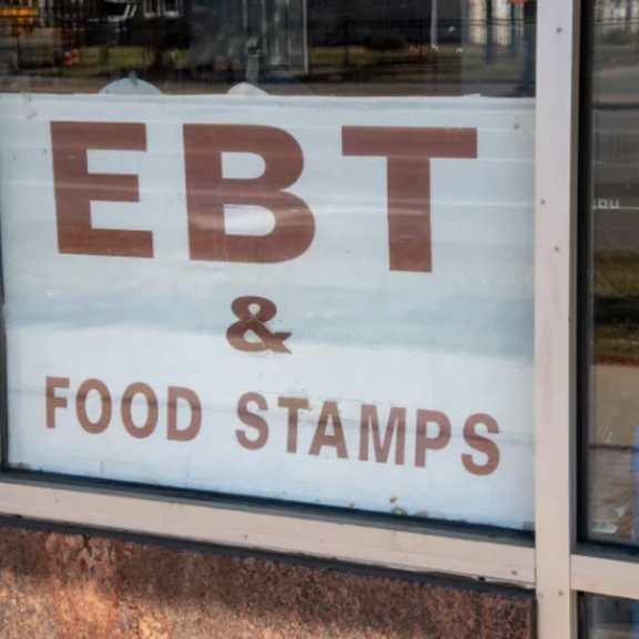 EBT and food stamps sign in store window.