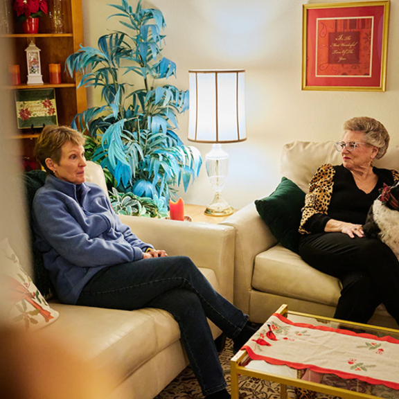 Two older adult women in their living room.
