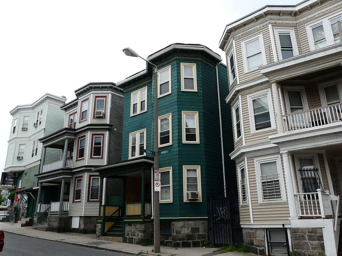View of triple-decker apartments on a street in Boston.