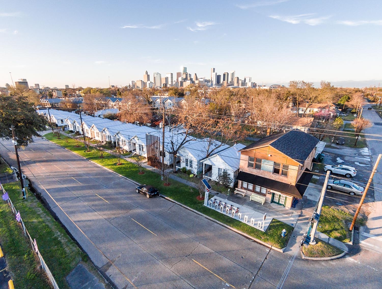 Aerial view of row houses with city skyline behind them