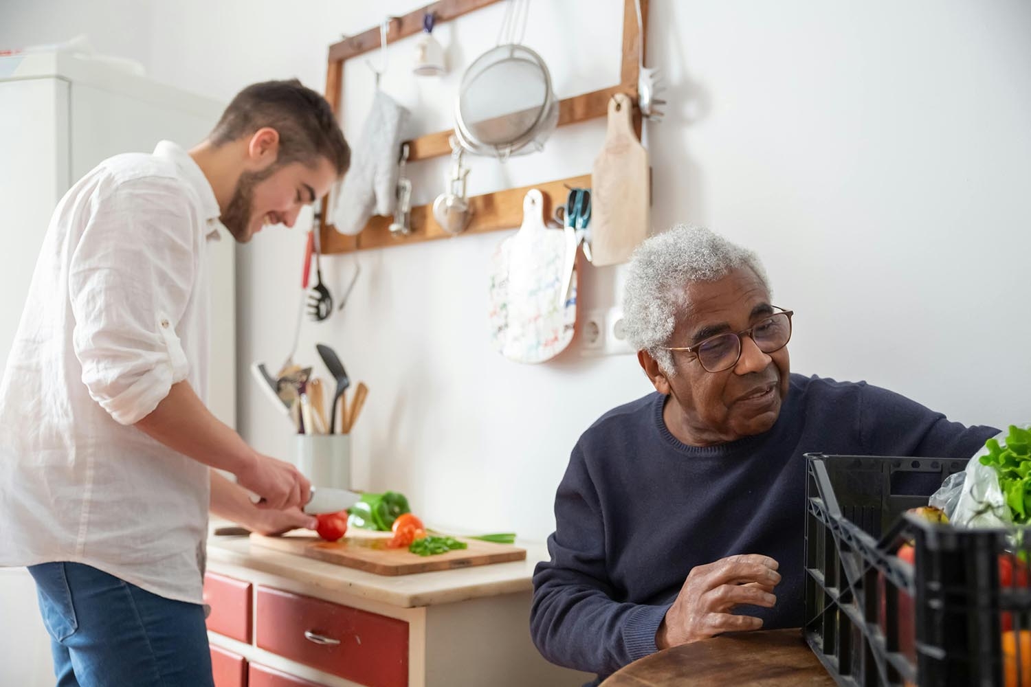 Caregiver cooks food for Black older adult resident