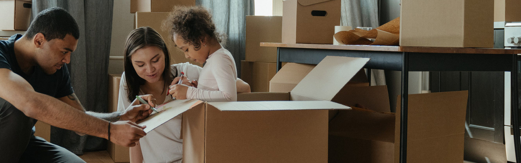 Family unpacking moving boxes